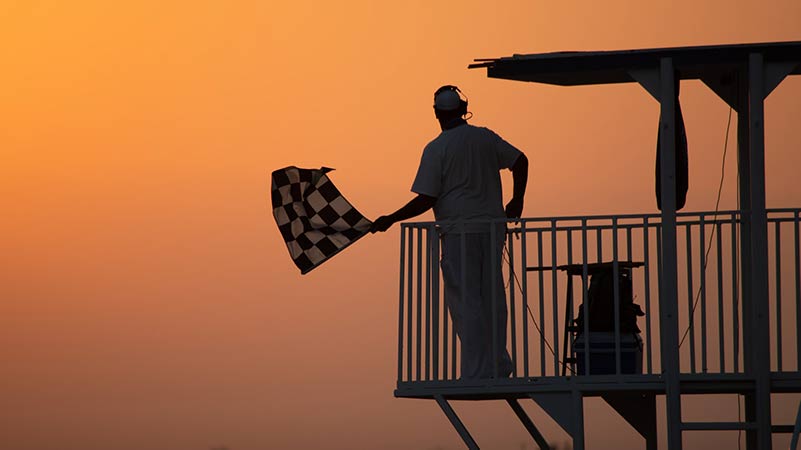 Silhouette of a man holding a race flag